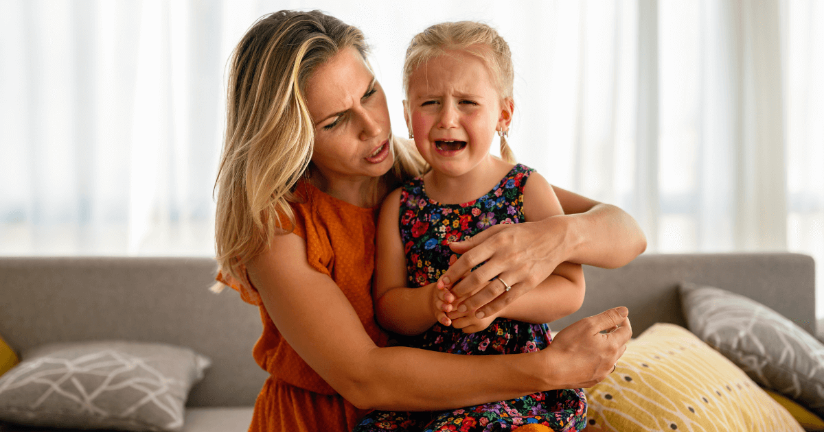 Upset child being comforted by it's mother.